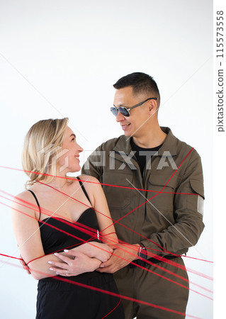 A young couple, a man and a woman, are wrapped in red threads. Dependency concept A young couple, a man and a woman, are wrapped in red threads. Dependency concept 115573558