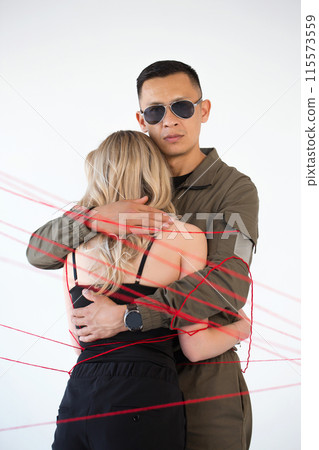 A young couple, a man and a woman, are wrapped in red threads. Dependency concept A young couple, a man and a woman, are wrapped in red threads. Dependency concept 115573559