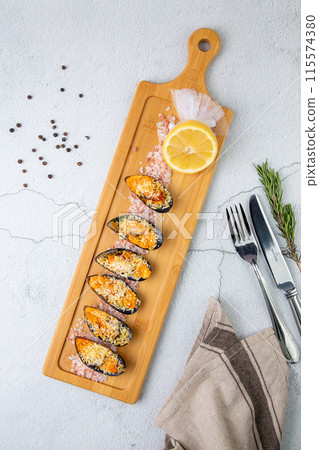 oysters scallops with red sea salt and citric acid on a wooden tray side view 115574380