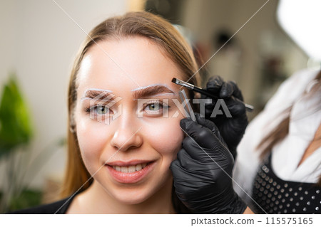 A portrait of a young woman having her brows dyed at beauty salon 115575165