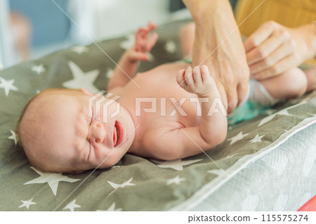 The newborn's skin is peeling. Mom uses skin products and massages to care for and soothe the baby's delicate skin, ensuring comfort and promoting healthy skin 115575274