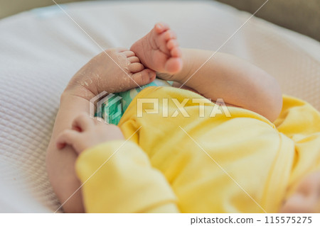 The newborn's skin is peeling. Mom uses skin products and massages to care for and soothe the baby's delicate skin, ensuring comfort and promoting healthy skin 115575275
