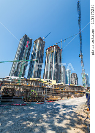 High-rise residential buildings under construction on blue sky background High-rise residential buildings under construction on blue sky background 115575283
