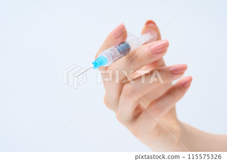 Hand with syringe 115575326