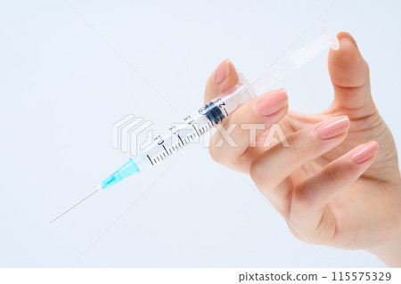 Hand with syringe 115575329