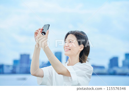A young woman operating a smartphone A young woman operating a smartphone 115576346