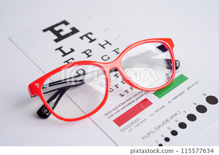 Glasses on eye exam chart to test eyesight accuracy of reading. Glasses on eye exam chart to test eyesight accuracy of reading. 115577634