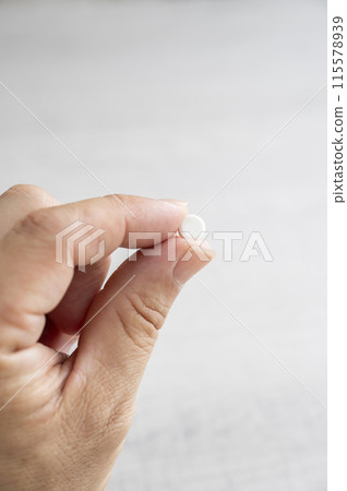 Pinch the medicine with your fingers Pinch the medicine with your fingers 115578939