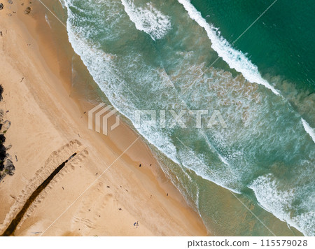 Aerial view sandy beach and big waves crashing on sandy shore, Beautiful tropical sea in the morning summer season image by Aerial view drone shot, high angle view Top down Aerial view sandy beach and big waves crashing on sandy shore, Beautiful tropical sea in the morning summer season image by Aerial view drone shot, high angle view Top down 115579028