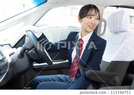 Image of a female driver wearing white gloves driving a taxi 115580751