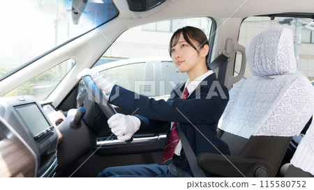 Image of a female driver wearing white gloves driving a taxi 115580752