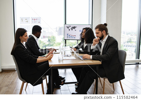 Business meeting with diverse team discussing data reports Business meeting with diverse team discussing data reports 115582464