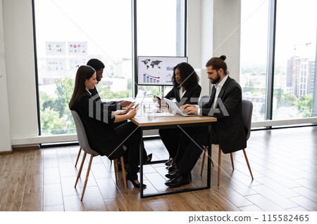 Diverse group of business professionals in a modern office meeting Diverse group of business professionals in a modern office meeting 115582465