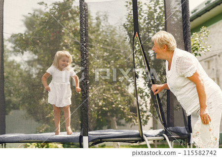 Family in a back yeard. Granddaughter with grandmother. 115582742