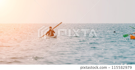 Woman sea kayak. Happy smiling woman in kayak on ocean, paddling with wooden oar. Calm sea water and horizon in background. Active lifestyle at sea. Summer vacation. 115582979