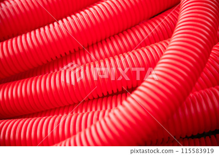 Red plastic tubing for underground cable protection as background  115583919
