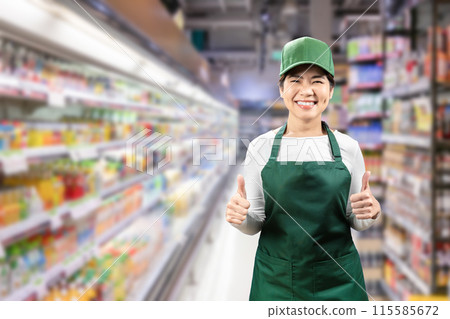 Asian seller wear green apron and cap smiling in retail store 115585672