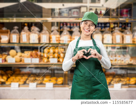 Asian seller wear green apron and green cap smiling Asian seller wear green apron and green cap smiling 115585677