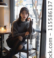 A woman relaxing at a cafe 115586137
