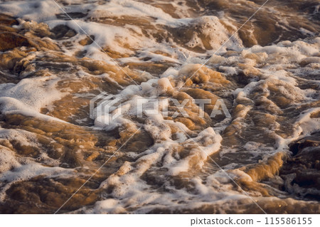A large rocks surrounded by waves of the ocean A large rocks surrounded by waves of the ocean 115586155