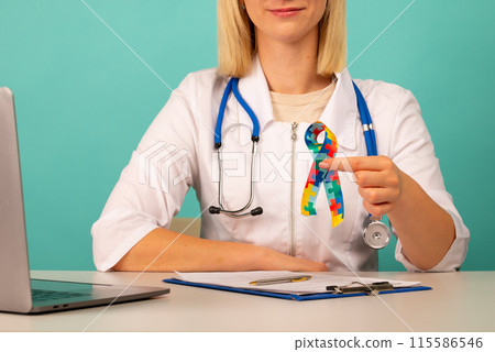 World Autism awareness and pride day with Puzzle pattern ribbon. The doctor's hand World Autism awareness and pride day with Puzzle pattern ribbon. The doctor's hand 115586546