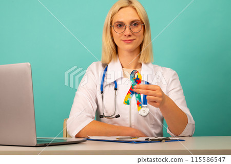 World Autism awareness and pride day with Puzzle pattern ribbon. The doctor's hand World Autism awareness and pride day with Puzzle pattern ribbon. The doctor's hand 115586547