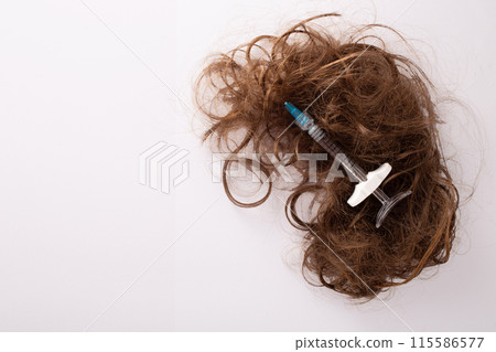 Hair treatment concept. Medical syringe and hair isolated on a white background 115586577