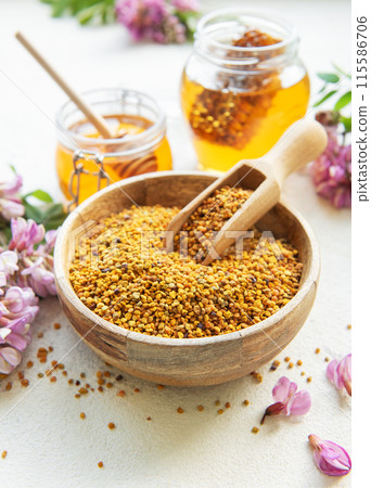 Raw organic bee pollen and honey in jars and acacia flowers. . Raw organic bee pollen and honey in jars and acacia flowers. . 115586706