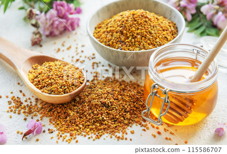 Raw organic bee pollen and honey in jars and acacia flowers. . Raw organic bee pollen and honey in jars and acacia flowers. . 115586707