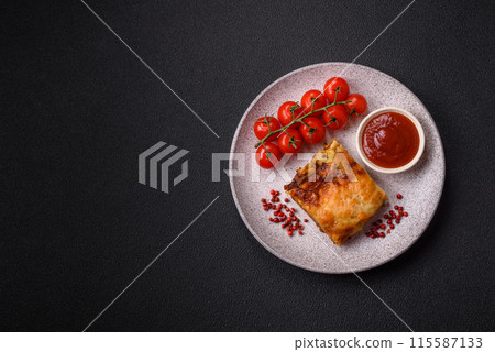 Delicious baked lasagna pasta with meat, sauce, salt, spices and herbs on a dark concrete background 115587133