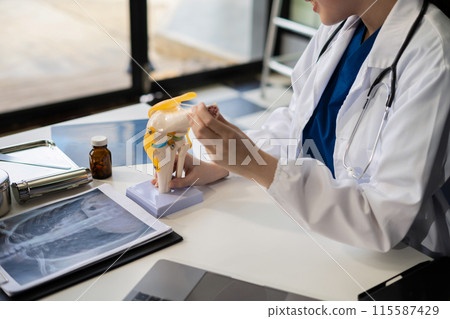 Doctor explain knee pain with model to patient, treatment to patients. 115587429