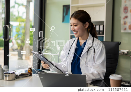 Doctor working on laptop computer, writing prescription clipboard with record information paper folders on desk in clinic, Healthcare and medical concept. 115587431