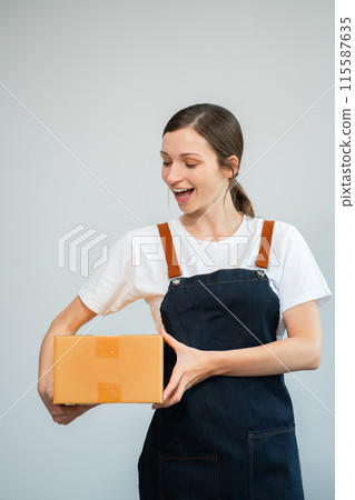 woman holding parcels box and looking to camera, isolated on white background. woman holding parcels box and looking to camera, isolated on white background. 115587635