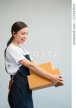 woman holding parcels box and looking to camera, isolated on white background. woman holding parcels box and looking to camera, isolated on white background. 115587642