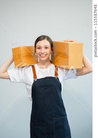 woman holding parcels box and looking to camera, isolated on white background. 115587648