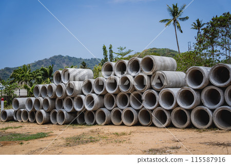 A stack of concrete ring pipes piled and creating a symmetrical arrangement 115587916