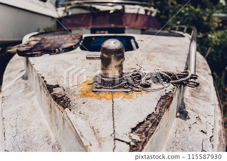 Old and rusty motor boats on a landfill surrounded by tropical forest 115587930