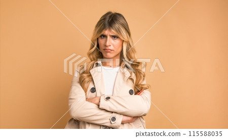 Disappointed transgender woman nodding head against beige background Disappointed transgender woman nodding head against beige background 115588035