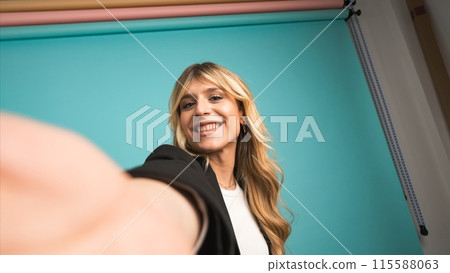 Happy transgender businesswoman puckering lips while taking selfie in studio Happy transgender businesswoman puckering lips while taking selfie in studio 115588063