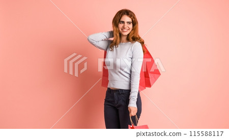 Happy shopaholic woman with shopping bags in pink studio 115588117