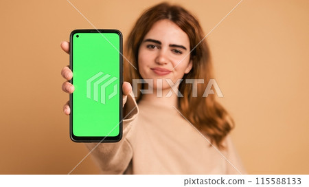 Happy woman showing mobile phone with chromakey in studio Happy woman showing mobile phone with chromakey in studio 115588133