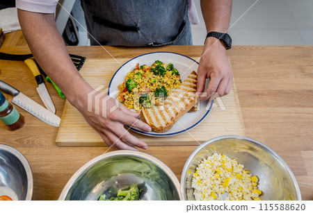 Chef at the kitchen preparing tofu scramble with vegetables 115588620