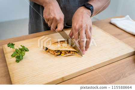 Chef at the kitchen preparing quesadillas with tofu and sweet corn Chef at the kitchen preparing quesadillas with tofu and sweet corn 115588664