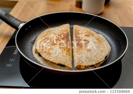 Chef at the kitchen preparing quesadillas with tofu and sweet corn Chef at the kitchen preparing quesadillas with tofu and sweet corn 115588669