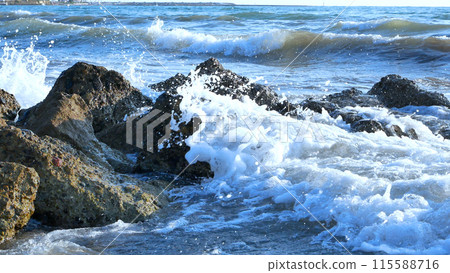 Sea waves with foam break on the rocks near the shore. Seascape. Sea waves with foam break on the rocks near the shore. Seascape. 115588716
