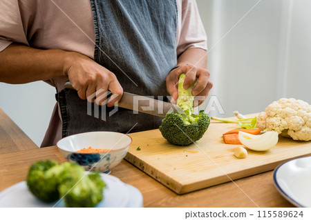 Chef at the kitchen preparing lentils soup with cauliflower and broccoli Chef at the kitchen preparing lentils soup with cauliflower and broccoli 115589624