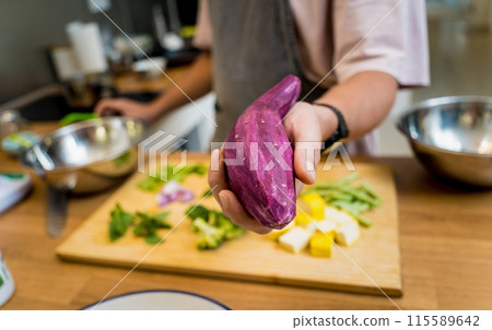Chef at the kitchen preparing green curry with herbs and rice 115589642