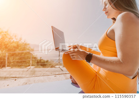 Woman laptop sea. Working remotely on seashore. Happy successful woman female freelancer working on laptop by the sea at sunset, makes a business transaction online. Freelance, remote work on vacation 115590357