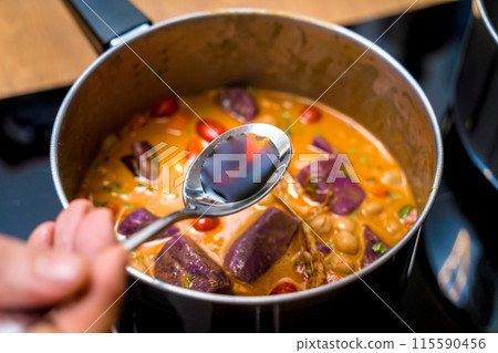 Chef at the kitchen preparing massaman curry with sweet potato and many spices Chef at the kitchen preparing massaman curry with sweet potato and many spices 115590456
