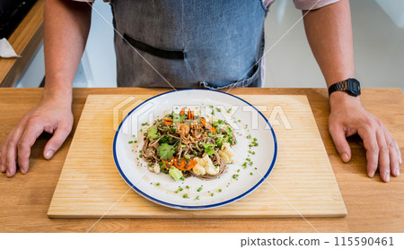 Chef at the kitchen preparing japanese buckwheat pasta with lentils 115590461